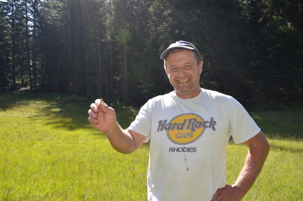 Robert Nesensohn hält Heuschrecke in der Hand