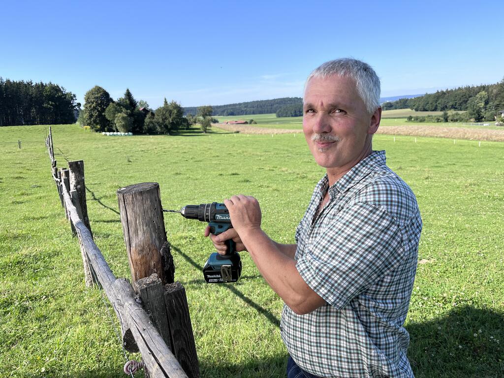 Gerhard Moser bei der Arbeit – mit dem Akkubohrer schafft er entlang der Weidezäune wertvolle Nistplätze.