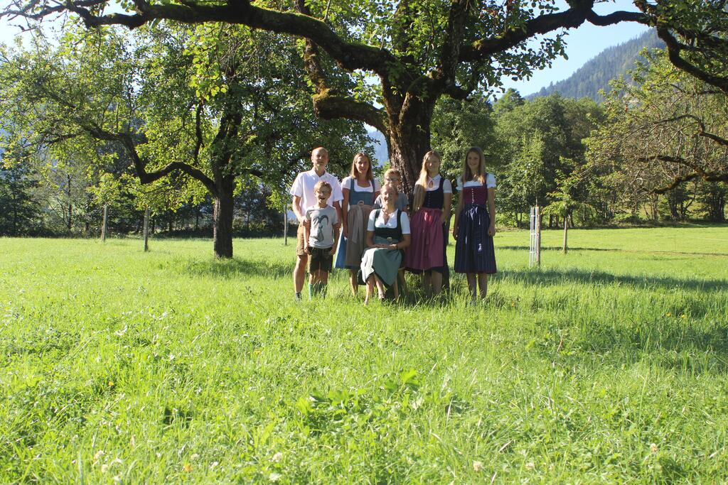 Eine Familie steht vor einem Apfelbaum 