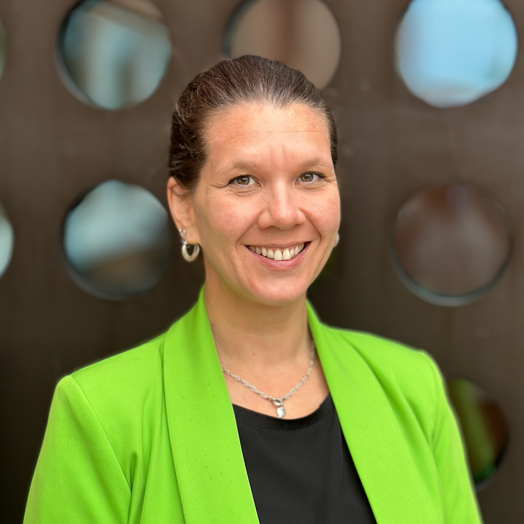 Frau mit braunen Haaren und grüner Jacke