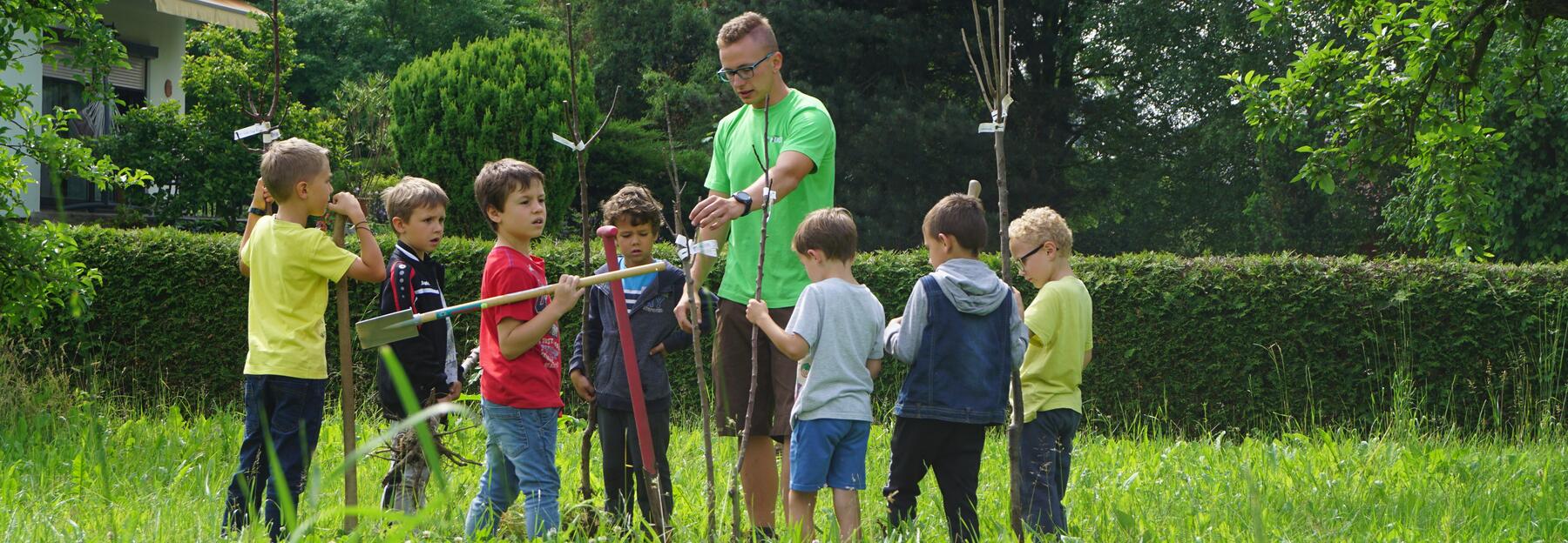 Ein LJ Mitglied erklärt den VS SchülerInnen, wie man einen Baum setzt und worauf man achten sollte.