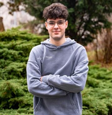 Junger Mann vor grünem Busch 