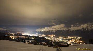 Das von der Stadt Innsbruck nach oben abgestrahlte Licht ist gut an der Aufhellung der Wolken zu erkennen