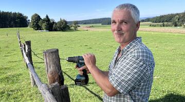 Gerhard Moser bei der Arbeit – mit dem Akkubohrer schafft er entlang der Weidezäune wertvolle Nistplätze.